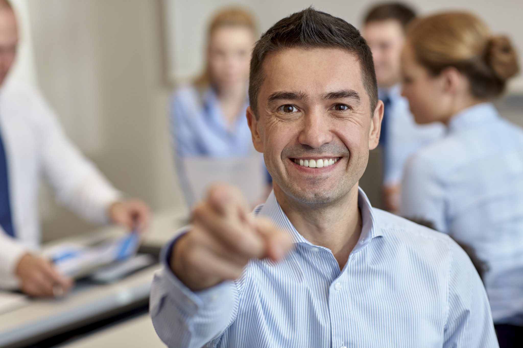 group of smiling businesspeople meeting in office